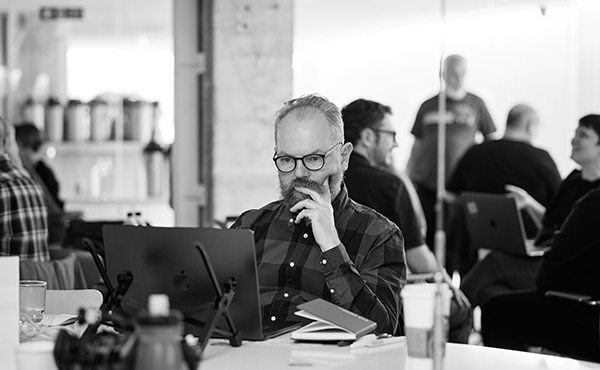 A member of the Equal Experts network looks intently at a laptop computer screen during a coworking day.