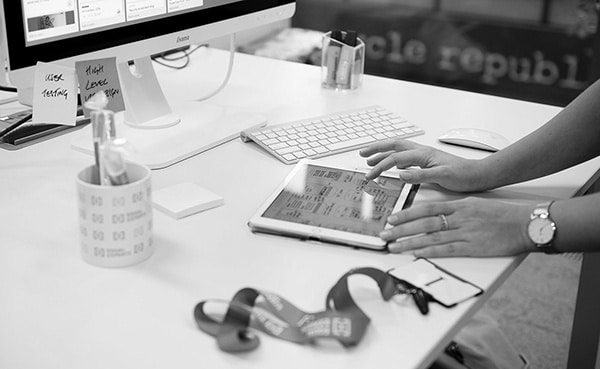 A person using a tablet computer on a desk during an Equal Experts coworking day.