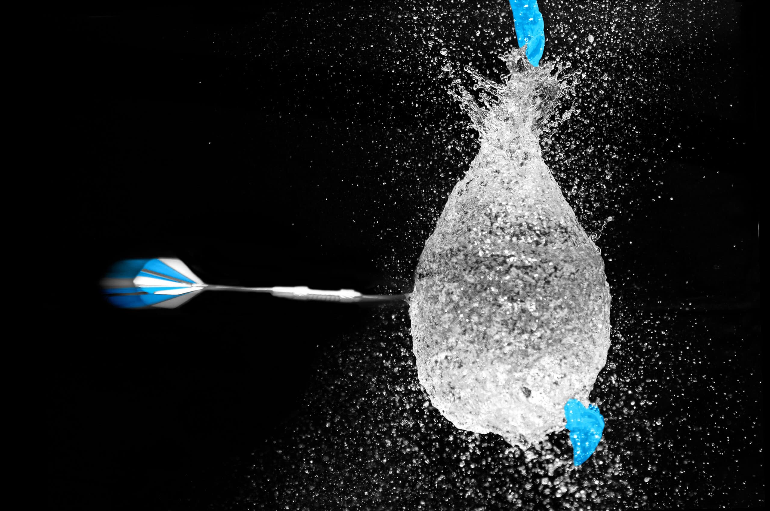 balloon bursting with dart flying towards it
